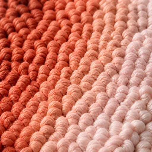 Détail de boucles de laine colorées piquées dans une toile